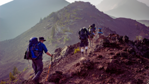 Climbers hiking with trekking sticks on a rugged mountain trail