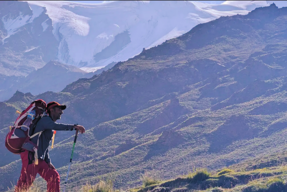 A man trekking uphill on a sunny day